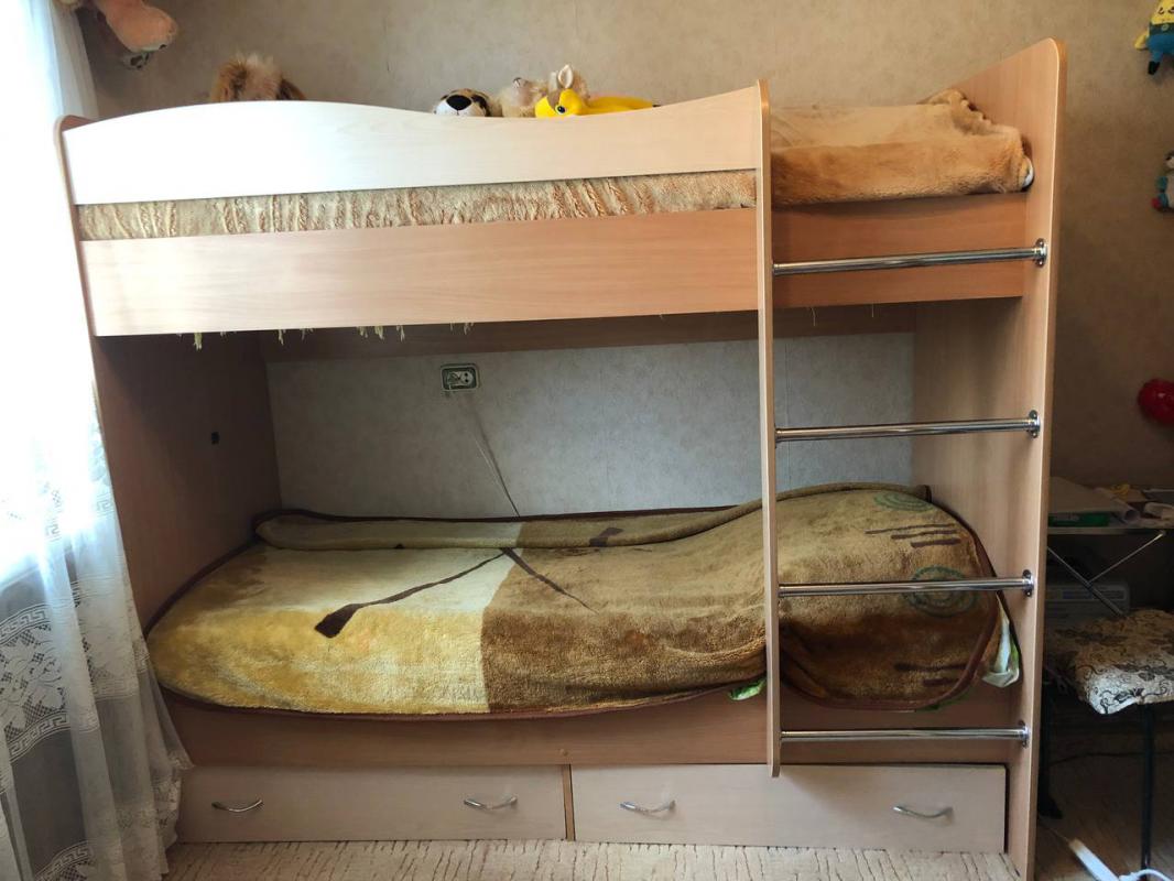 Продается уютная двухъярусная кровать с матрасами, выполненная из ЛДСП в приятном бежевом цвете. - Гай